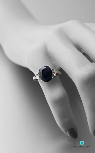 null 750 thousandths white gold ring adorned with an oval-shaped sapphire calibrating...