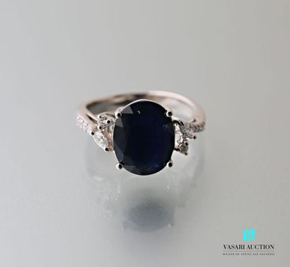 null 750 thousandths white gold ring adorned with an oval-shaped sapphire calibrating...