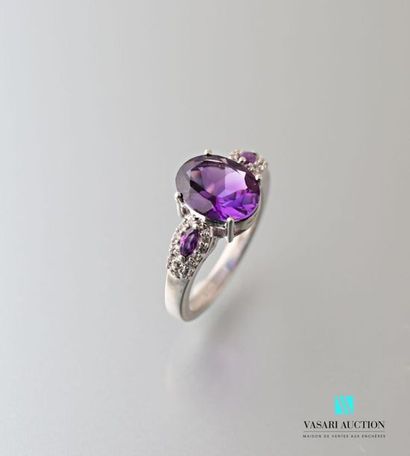 null Silver ring centered on an oval amethyst shouldered by two shuttle amethysts...