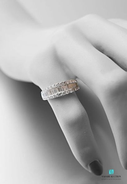 null 750 thousandths white gold rush ring adorned in its center with a line of baguette-cut...