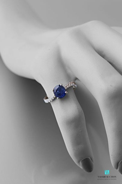 null A sinuous 750 thousandths white gold ring set with an oval-shaped sapphire calibrating...