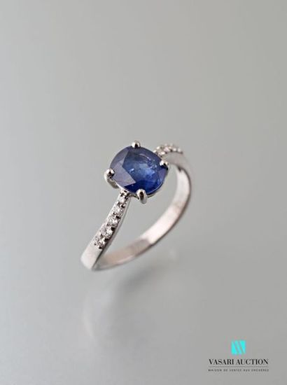 null A sinuous 750 thousandths white gold ring set with an oval-shaped sapphire calibrating...