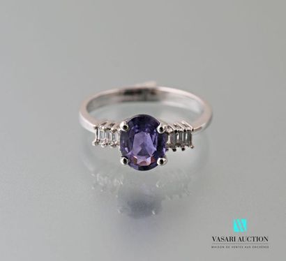 null 750 thousandths white gold ring centered on an oval-shaped lilac sapphire calibrating...