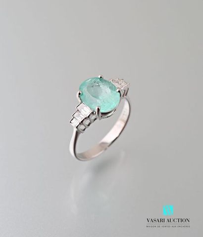 null A 750 thousandths white gold ring set with an oval emerald of approximately...
