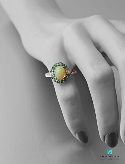 null Silver ring centered with a cabochon cut opal hemmed with Tsavorites.
Gross...