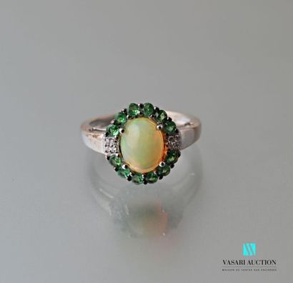 null Silver ring centered with a cabochon cut opal hemmed with Tsavorites.
Gross...