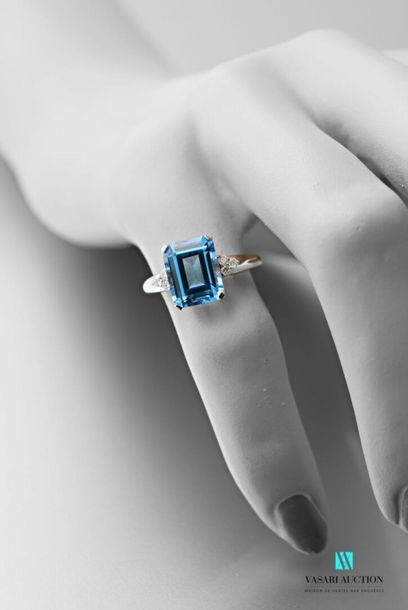 null A 750 thousandths white gold ring adorned at its centre with an emerald-cut...