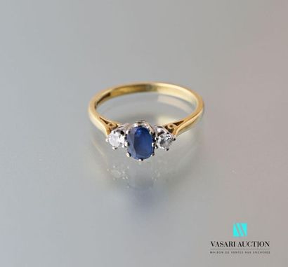 null Yellow gold ring 750 English mils set with a central sapphire shouldered by...