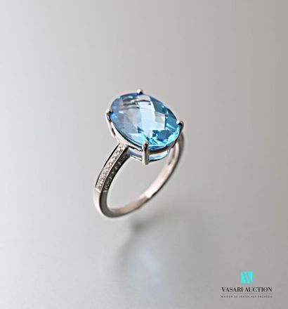 null A 750 thousandths white gold ring adorned with an oval-shaped topaz calibrating...