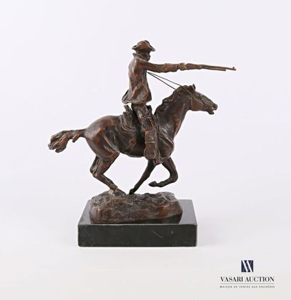 null Bronze subject with a brown patina representing a cowboy riding a horse, it...