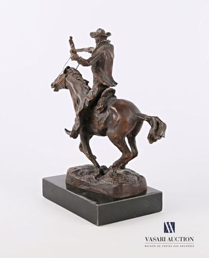 null Bronze subject with a brown patina representing a cowboy riding a horse, it...