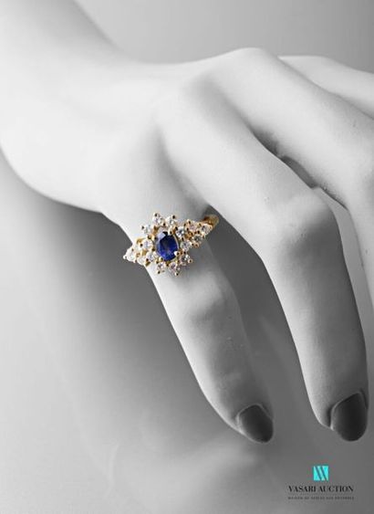 null 750-thousandths yellow gold ring centered on an oval sapphire surrounded by...