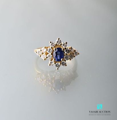 null 750-thousandths yellow gold ring centered on an oval sapphire surrounded by...