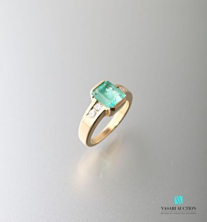 null 750 thousandths yellow gold ring set with a rectangular emerald shouldered with...