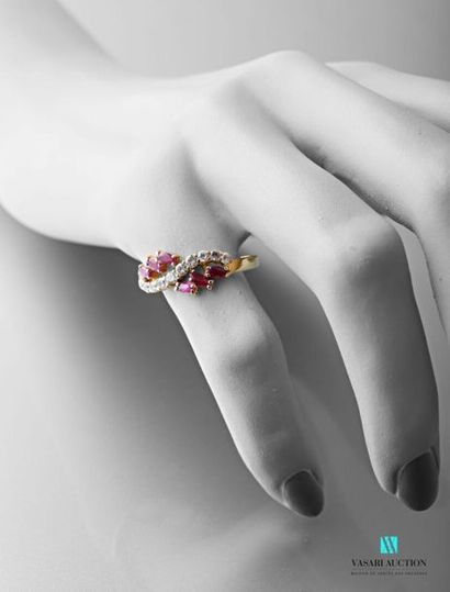 null 750 thousandths yellow gold ring set with six shuttle rubies supporting an undulating...