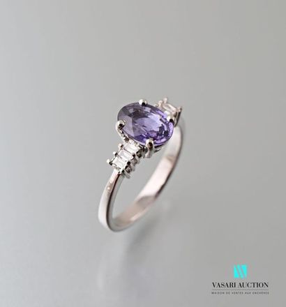 null 750 thousandths white gold ring centered on an oval-shaped lilac sapphire calibrating...