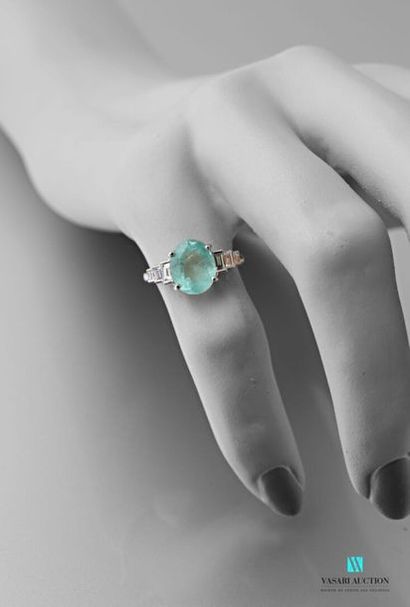 null 750 thousandths white gold ring set with an oval-cut emerald of approximately...