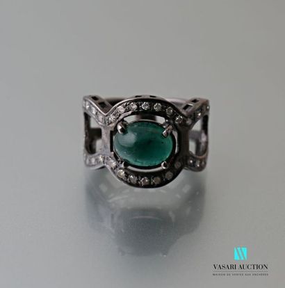 null Patinated silver ring with an openwork and polylobé body centered on an emerald...