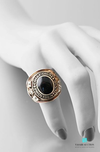null 9 karat gold university ring set with a cabochon onyx surrounded by the inscription...