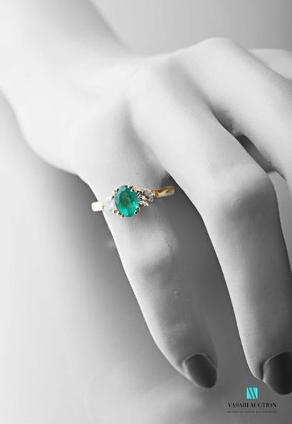 null 750 thousandths yellow gold ring set with a central oval emerald with two 0.20...