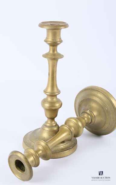null Pair of brass candleholders resting on a round to soft base, baluster-shaped...