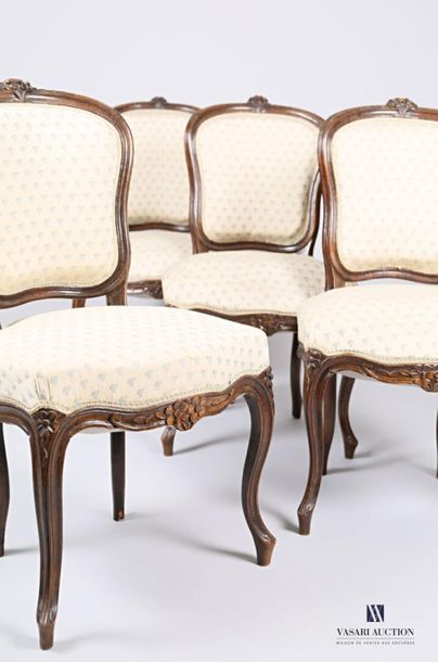 null A suite of four chairs in moulded and carved natural wood with flower decoration,...