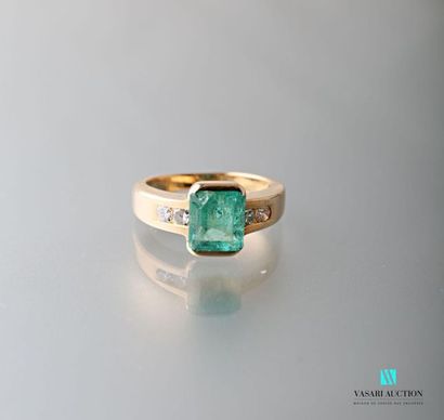 null 750 thousandths yellow gold ring set with a rectangular emerald shouldered with...