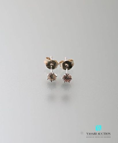 null Pair of 750 thousandths white gold ear studs adorned with two round diamonds...