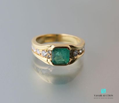 null 750 thousandths yellow gold ring set with a square-cut central emerald with...