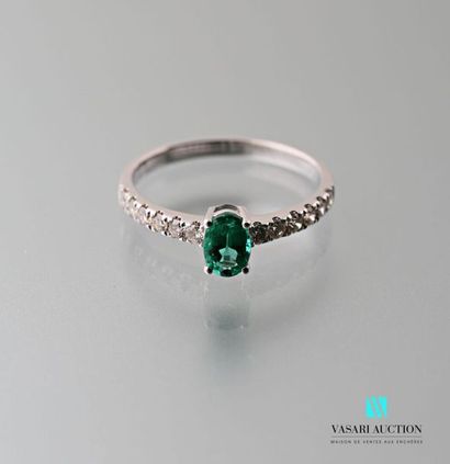 null 750 thousandths white gold ring set with an oval-cut emerald calibrating approximately...