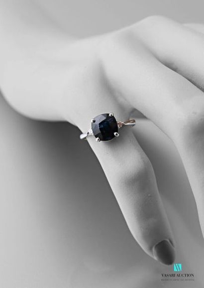 null 750 thousandths white gold ring set in its center with a cushion-cut sapphire...