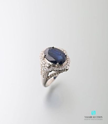 null 750 thousandths white gold ring adorned in its center with an oval-shaped sapphire...
