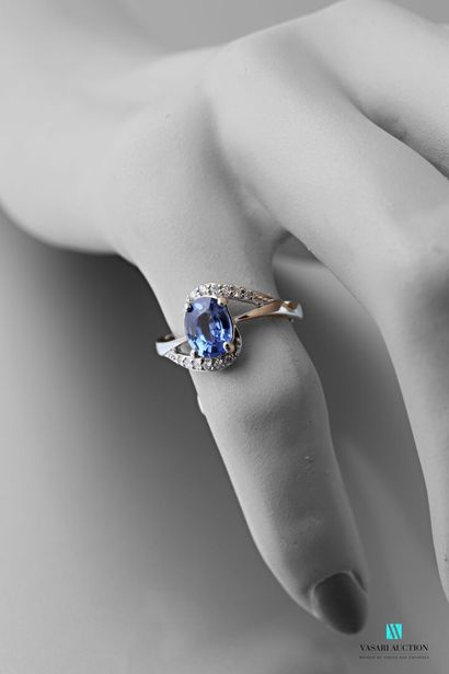 null Asymmetrical ring in 750 thousandths white gold set with an oval-cut sapphire...