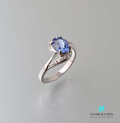 null Asymmetrical ring in 750 thousandths white gold set with an oval-cut sapphire...