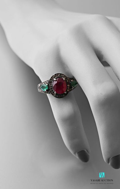 null Patina silver ring centered on an oval cut ruby shouldered with two pear cut...