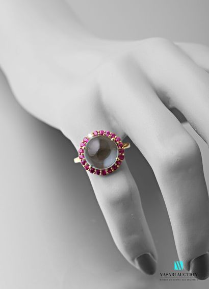 null Vermilion ring centered with a cabochon-cut light blue topaz in a round ruby...