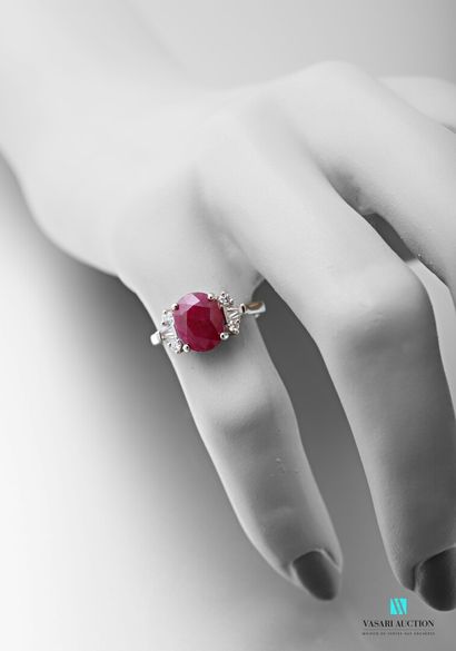 null 750 thousandths white gold ring set in its centre with an oval-shaped ruby calibrating...
