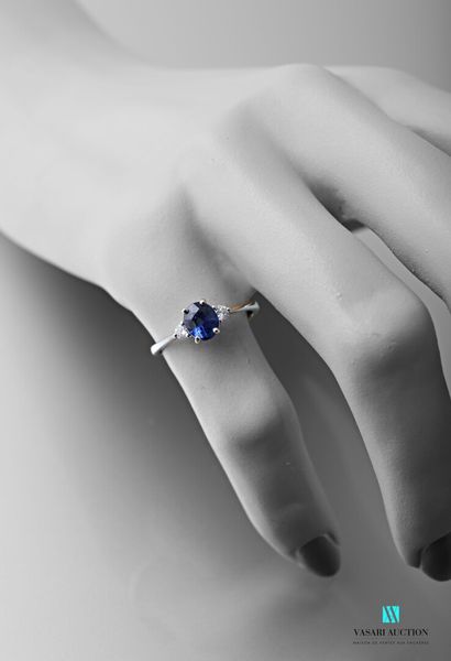 null 750 thousandths white gold ring set with an oval-shaped sapphire calibrating...