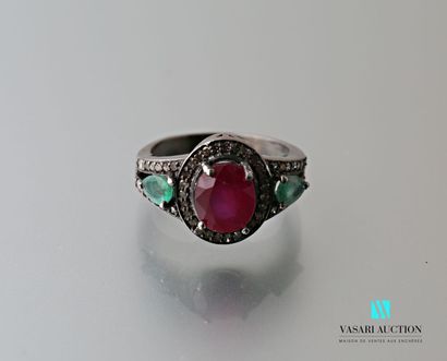 null Patina silver ring centered on an oval cut ruby shouldered with two pear cut...