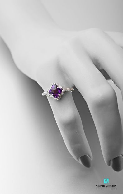 null A 750 thousandths white gold flower ring adorned in its centre with a four-lobed,...