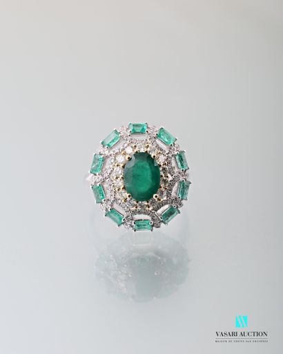 null 750 thousandths white gold ring adorned in its centre with an oval-cut emerald...