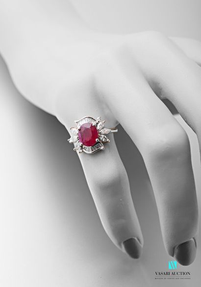 null 750 thousandths white gold ring set in its centre with an oval-shaped ruby calibrating...