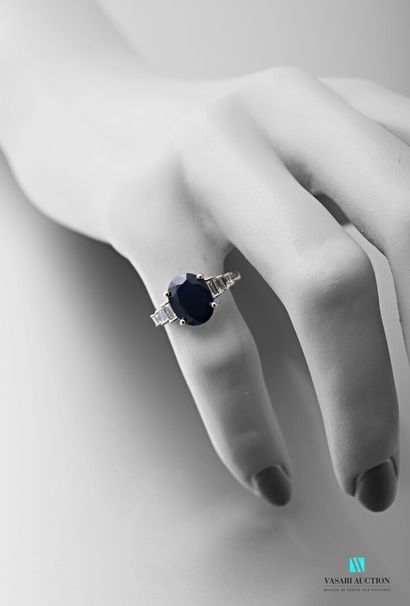 null White gold ring set with an oval-shaped sapphire calibrating approximately 2.95...