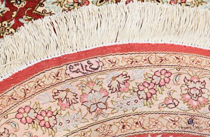 null Tapis ovale en soie à décor d'une rosace fleurie sur fond rouge, la bordure...