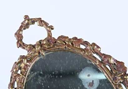null Miroir en bronze à vue ovale, il s'inscrit dans un médaillon à décor ajouré...