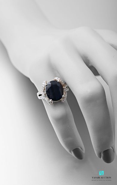 null 750 thousandth white gold ring set in its centre with an oval-shaped sapphire...