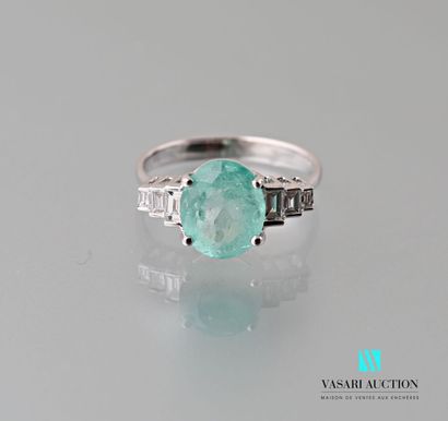 null A 750 thousandths white gold ring set with an oval emerald of approximately...