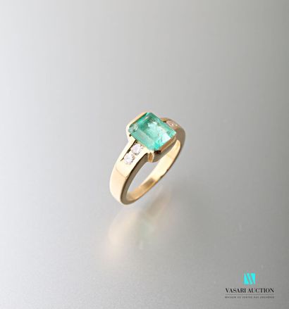 null 750 thousandths yellow gold ring set with a rectangular emerald shouldered with...