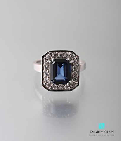 null 750-thousandths white gold ring set with an emerald-cut sapphire calibrating...