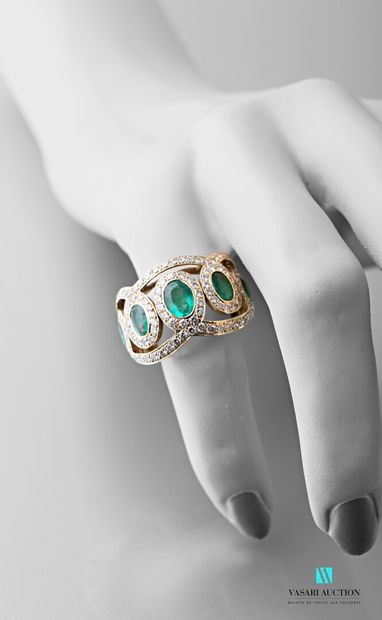 null 750 thousandths yellow gold ring set with emeralds in a circle of diamonds 

Gross...